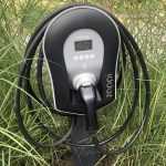 Elektrische auto beschikbaar voor kortverhuur met laadpunt, symboliserend duurzame mobiliteit voor bedrijven