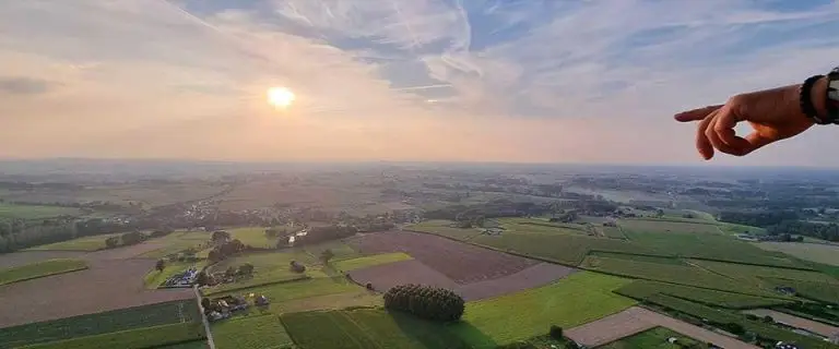 Gezin geniet van ballonvaart in Vlaams-Brabant voor kinderen met uitzicht op landschap vanuit de lucht